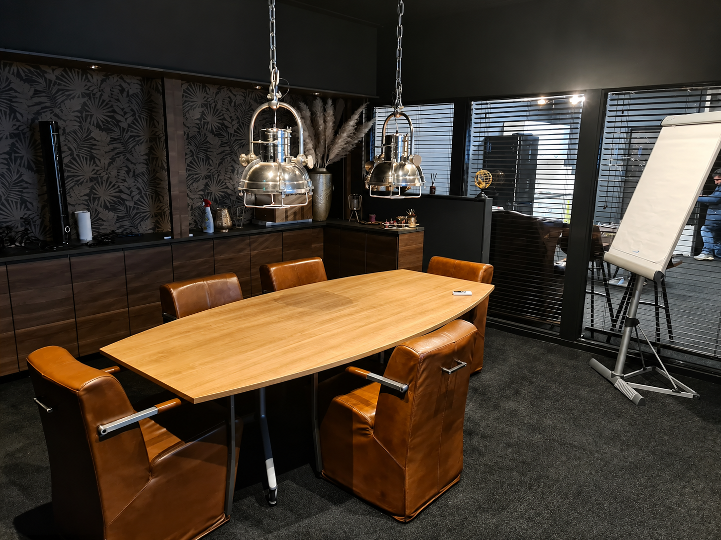 Trainingsruimte in Huizen met ruime tafel, stoelen, presentatiescherm en flip-over